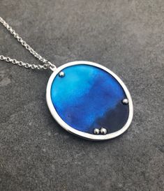 "This blue enamel pendant is made from Sterling Silver and beautiful blue enamels. The pendant is oval in shaoe and has a silver border surrounding the blue enamels and fine silver 'bubbles ' detail. It measures approx: 3 x 2.5cm and hangs on a 2mm wide chain with an 18\" chain length." Sea Necklace, Oval Necklace, Enamels, Necklace Blue, Blue Necklace, Fine Silver, Beautiful Blue, Chain Lengths, Ibiza