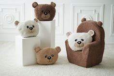 three stuffed bears sitting on top of white cubes in the middle of a room