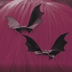 two bats that are on top of a pink hair