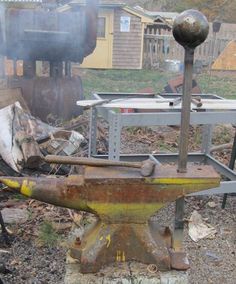 an old metal hammer sitting on top of a piece of wood next to a fire hydrant