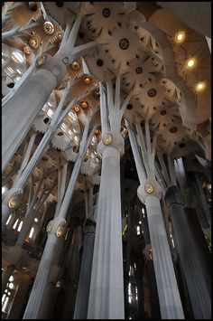 the inside of a building with many columns and lights hanging from it's ceiling