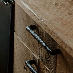 a close up of a drawer on a wooden surface with metal handles and knobs