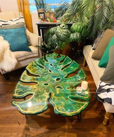 a living room filled with furniture and lots of green plants on top of the coffee table