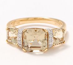 three stone ring with diamonds on the sides and an oval cut diamond in the middle