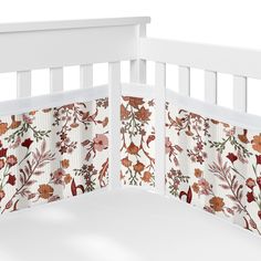 a white crib with red and orange flowers on it