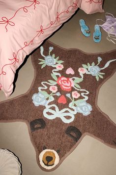 a teddy bear rug is on the floor next to some shoes and a pink pillow