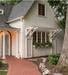 a white house with a brick walkway leading to the front door and entryway area