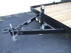 a black trailer with a chain on the front and two wheels attached to it's sides