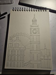 a drawing of a clock tower on top of a building next to a laptop computer