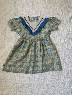 Vintage 40s/50s  handmade dress. This dress is so special and has the sweetest details!  Size 3/4 In my opinion  Good vintage condition for the age. The fabric is faded and there are two small mends (see photos). 1940s Kids Fashion, Vintage Cotton Dress For Dress-up, Vintage Blue Dress With Doll Collar, Vintage Ruffled Dress For Tea Party, Vintage Dress With Ruffles For Tea Party, Retro Dress With Ruffles And Peter Pan Collar, Retro Dress With Peter Pan Collar And Ruffles, Vintage Peter Pan Collar Dress For Garden Party, Vintage Cotton Dress With Yoke Detail