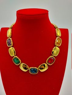 "This gleaming gold plated necklace is from iconic Napier, 1991 \"Royalton\" series, in Excellent condition ready to impress! It showcases Swarovski crystal rhinestones in rectangular settings~~emerald green, ruby red, golden amber, amethyst purple, and sapphire blue. It is signed on the fold over closure and in back, and measures 17\" long by 7/8\" wide. A glorious tribute to the unrivaled quality and impeccable styling of Napier, a company with well-deserved Collectible status!" Gold Hallmarked Necklace For Party, Luxury Jeweled Necklaces For Formal Occasions, Luxury Jeweled Necklace For Formal Occasions, Gold Necklaces With Stones For Party, Gold Plated Jeweled Necklace For Formal Events, Gold Jewelry With Stones For Evening, Gold Plated Gold Necklace With Stones, Jeweled Yellow Gold Necklaces For Anniversary, Jeweled Yellow Gold Necklace For Anniversary