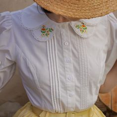 A retro blouse with small brightly blooming flowers embroidered on the collar. The design has pleats on the chest and bulges on the shoulders. It will make you look like a pure and gorgeous lady. The retro and adorable atmosphere makes your heart beat faster just by wearing it. 
 
 Size 
 
 
 S size 
 
 Length: 57cm 
 Shoulder width: 34cm 
 Bust: 91cm 
 Sleeve length: 33cm 
 
 M size 
 
 Length: 58cm 
 Shoulder width: 35cm 
 Bust: 95cm 
 Sleeve length: 34cm 
 
 L size 
 
 Length: 59cm 
 Shoulder Vintage Lace Collar Top For Spring, Embroidered Spring Tops With Ruffled Collar, Fitted Summer Blouse With Doll Collar, Summer Fitted Blouse With Doll Collar, Spring Blouse With Peter Pan Collar, Spring Blouse With Floral Embroidery And Ruffled Collar, Cute Spring Blouse With Peter Pan Collar, Fitted Cotton Blouse With Cute Collar, White Doll Collar Top With Floral Embroidery