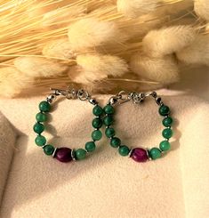 Discover the elegance of our handmade Huggie hoop earrings, featuring natural Indian emerald and ruby beads. These exquisite earrings boast a unique combination of vibrant green and rich red gemstones, elegantly set with rhodium-plated hardware to ensure a long-lasting, tarnish-resistant finish. Hypoallergenic and comfortable for everyday wear, these earrings are perfect for those with sensitive ears. Details: Diameter: 3 cm (inches). Closure: Post-back for secure fit. Materials: Natural emerald Green Dangle Hoop Earrings For May Birthstone, Luxury Handmade Green Hoop Earrings, Green Hoop Earrings With Colorful Beads, Festive Dual-tone Green Earrings, Green 14k Gold-filled Dangle Earrings, Ruby Beads, Red Gemstones, Huggie Hoop Earrings, Natural Emerald