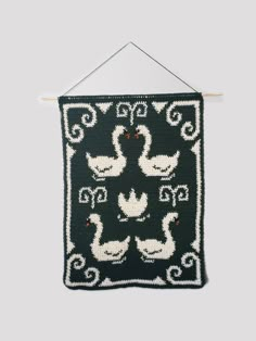 a black and white knitted wall hanging with ducks