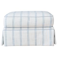 the blue and white striped bedding is folded on top of an ottoman with pleaed edges