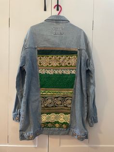 Indie embroidered denim jackets are handmade by Esme in Manchester UK.  Esme upcycles second-hand denim jackets and gives them a new lease of life by adding beautiful Indian braid and embroidered textiles.  Size U.K. Small  Hip length jacket  Stone washed denim with gorgeous green and gold Indian braid at the back panel, two pouch pockets and hip pockets at the front of the jacket and popper metal button fastening at front.  Jacket measurements approx: Half chest: 55cm Half hem: 55cm Sleeve length (from arm hole): 59cm Center back length: 78cm Each piece is hand picked by Esme and loving re-worked to create a hippie unique jacket. Esme designs each piece unique so you will never find two the same. Indian Braids, Embroidered Textiles, Customised Denim Jacket, Style Festival, Smaller Hips, Unique Jackets, Embroidered Denim Jacket, Festival Style, Embroidered Denim