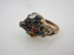 "A lovely vintage 18k gold and multi stone ring, featuring mainly sapphires. The style is known as a Thai Princess ring, with it's gemstone studded pointy top. Marked \"18k\". US size 5.5 and is resizable at any jeweler. Actual packaging will vary depending on item/s purchased and tape pattern available. Props shown in photos is for display purposes only, not included in this listing. As always, satisfaction is guaranteed. Thanks for shopping Vintage In Bloom More rings: http://www.etsy.com/shop Antique Multi-stone Yellow Gold Cluster Ring, Antique Oval Multi-stone Ring, Antique Multi-stone Cluster Ring In Yellow Gold, Vintage Multi-stone Sapphire Ring In 14k Gold, Heirloom Multi-stone Cluster Ring, Antique Gold Multi-stone Ring, Vintage Multi-stone Gold Ring, Vintage Gold Multi-stone Cluster Ring, Vintage Multi-stone Sapphire Ring