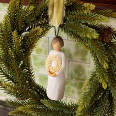 a christmas ornament hanging on a wreath with pine cones and other holiday decorations