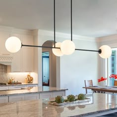 a large kitchen with marble counter tops and an island in front of the dining room table