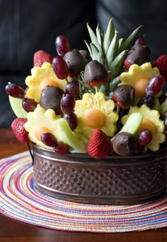 a fruit arrangement in a metal container on a table