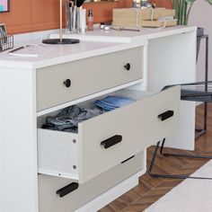 a white desk with two drawers and a lamp on top in front of the desk