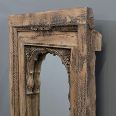 an old wooden mirror hanging on the wall