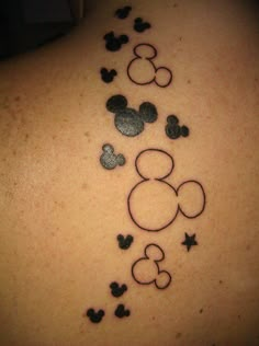 the back of a woman's neck with mickey mouse tattoos on it