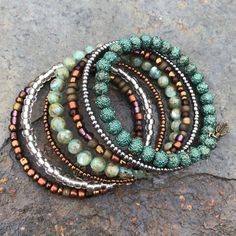 Beautiful, Handmade, 7 Layer Memory Wire Wrap Bracelet Featuring Natural Shell, Metal, And Glass Beads. Colors Ranging From Various Shades Of Green, Brown, And Silver In Both Metallics And Mattes. Beads On Antique Gold Color Memory Wire With Feather Charm At Each End. Memory Wire Helps Maintain Bracelet's Shape While Flexing To Fit Most Wrists. Diameter Approx 2.25”. Width Of Bracelet Approx 1.5”. Handmade By Three Magnolias. Memory Wire Bracelets Ideas, Memory Wire Bracelets Diy, Wire Bracelets Diy, Stretch Beaded Bracelets Diy, Silver Wrap Bracelet, Memory Wire Jewelry, Jump Ring Jewelry, Memory Wire Wrap Bracelets, Wire Wrap Bracelet