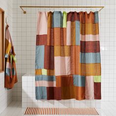 a colorful shower curtain in a bathroom next to a window