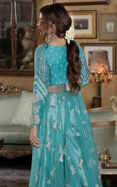 Verdigris full-sleeved Pishwas in chiffon with a leaf neckline, paired with a matching tissue sharara. Discover long Anarkali dresses, festive Anarkali suits, and elegant options for bridesmaids.Witness the enchanting beauty of the verdigris festive ensemble, a visual symphony that resonates with the soul and dances to a captivating folk melody. Adorned with intricate silver embellishments, this attire breathes life into the essence of tradition, exuding an exquisite charm that captivates the be Designer Sequin Dresses For Eid, Blue Sequin Dress For Reception, Blue Organza Embellished Dress, Blue Embellished Organza Dress, Traditional Silver Designer Dresses, Blue Embellished Dress For Reception, Embellished Blue Dresses For Reception, Embellished Blue Dress For Reception, Blue Anarkali Set With Sequins For Reception