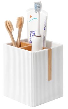 a toothbrush holder with two toothpaste tubes and one toothbrush in it