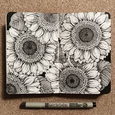 a notebook with sunflowers drawn on it and a marker pen next to it