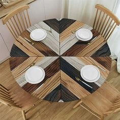 a wooden table topped with white plates and silverware