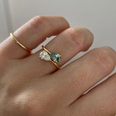 a woman's hand with a gold ring and two stone rings on her fingers