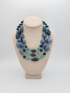 "Vintage Chico's Three-Strand Blue, Navy & Aqua Beaded Bib Necklace  This eye-catching necklace makes a great statement piece!  The necklace is made up of 3 strands of various shapes of beads in blue, navy & aqua colors.  The beads are strung on silver-tone wire & secure with a lobster claw clasp.  The necklace is adjustable for length.  This necklace is in excellent vintage condition with very little wear.    Dimensions: 21 1/2\" maximum Clasp: Lobster Claw Markings: Chico's Condition:  Excellent - very little wear All of my shop items are pre-owned vintage.  All pieces should be expected to have some vintage wear unless otherwise stated.   Great for the vintage & costume jewelry lover!  Be sure to check out our other vintage jewelry listings! Looking for something that isn't listed in my Adjustable Blue Multi-strand Long Necklace, Bohemian Blue Long Necklace With Faceted Beads, Blue Adjustable Multi-strand Long Necklace, Blue Multi-strand Necklace With Large Beads, Beaded Bib Necklace, Aqua Beads, Hippie Necklace, Retro Women, Aqua Color