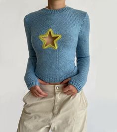 a woman wearing a blue sweater with a yellow star on it