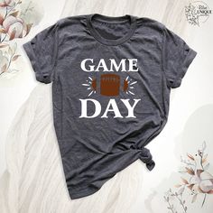 Game Day T-Shirt Football Fan Shirt, Sports Tee, Football Season Shirts, Funny Men Women Team Sports Tshirt, Football Game Day T-Shirts. The Game Day T-Shirt Football Fan Shirt is perfect for showcasing your team spirit during football season. This "Sports Tee" is ideal for both men and women who love the game. Celebrate football season in style with the "Football Season Shirts." The "Funny Men Women Team Sports Tshirt" adds a humorous touch to your game day outfit. Wear the "Football Game Day T-Shirts" to support your team and enjoy the excitement of the season. Hello, Welcome to Blue Unique Boutique, your destination for unique and handcrafted shirts! I'm Eve! I have been thinking about creating my business for a long time and now I have taken the first step towards it and it gives me ex Athletic Heather T-shirt With Letter Print For Sports, Athletic Heather Crew Neck T-shirt For Game Day, Athletic Heather Graphic Tee For Sports Events, Gray Graphic Tee For Sports Events, Athletic Heather T-shirt For Game Day, Graphic Tee T-shirt With Letter Print For Team Events, Athletic Heather T-shirt With Team Spirit Letter Print, Athletic Heather T-shirt With Letter Print For Team Spirit, Heather Gray T-shirt For Sports Events