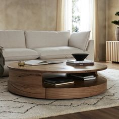 a living room with a couch, coffee table and rug on the floor in front of it