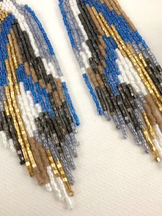 "Abstract gold and electric blue beaded earrings, statement boho earrings, unique earrings Length 5\" including ear wire Width 1\" Made with best quality Japanese seed beads and 24k gold dipped seed beads Lightweight and unique extravagant style - designed and made by Luba Ro Colors used - electric blue, white, hematite black, gold, dark khaki and silver gray Select closure earwires leverbacks clip-ons for non pierced ears" Handmade Blue Chandelier Earrings, Artisan Blue Earrings For Festival, Artisan Blue Earrings With Dangling Beads, Festival Blue Chandelier Earrings With Colorful Beads, Unique Blue Beaded Earrings For Festivals, Artisan Blue Beaded Earrings With Colorful Beads, Blue Beaded Dangle Earrings, Bohemian Blue Earrings With Gold Beads, Artisan Blue Beaded Earrings With Tiny Beads