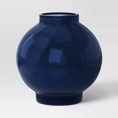 a large blue vase sitting on top of a white table