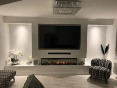 a large flat screen tv mounted to the wall above a fireplace in a living room