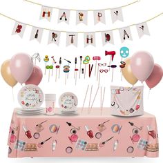 a pink table topped with lots of balloons