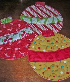 three christmas ornaments are sitting on the table