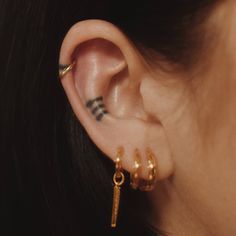 a close up of a person's ear with two piercings on top of it