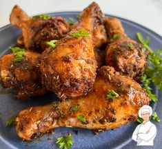 chicken wings with herbs and seasoning sitting on a blue plate, ready to be eaten