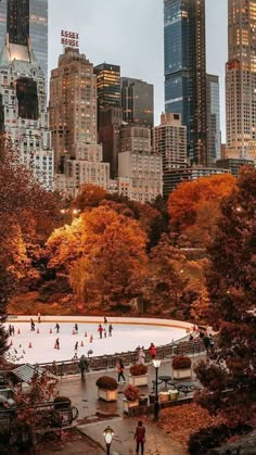 people skating on an ice rink in central park, new york city with the empire building in the background