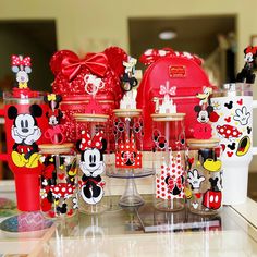 many mickey mouse cups and mugs are on display