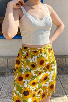 Your next favorite statement piece. Two subtle slits at the front add light detail to the summer mini skirt. A hand painted sunflowers print adorn the skirt. With warm yellow shades emanating bright, cheerful vibes, it's hard not to love this little number. The beautifully hand-painted sunflower print makes this a confidence-boosting style. The Rachel Skirt in Sunees creates a summery, colorful outfit full of vibrant energy. The floral mini skirt is made from 100% linen Floral Print Mini Skirt For Summer Beach, Summer Floral Print Mini Skirt For Vacation, Summer Mini Skirt With Floral Print For Vacation, Linen Mini Skirt For Day Out, Summer Cotton Mini Skirt For Vacation, Summer Floral Print Mini Skirt For Day Out, Cotton Mini Skirt For Summer Vacation, Cotton Mini Skirt For Vacation, Floral Print Mini Skirt For Summer Day Out