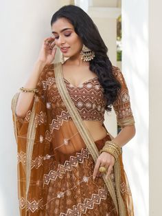 Indulge in the timeless elegance of this enchanting brown butterfly net lehenga adorned with intricate details of cotton threadwork, sequins, and embroidered motifs. The rich, earthy hue adds a touch of sophistication to your ensemble, while the delicate craftsmanship enhances its allure.
The semi-stitched lehenga boasts a generous 3-meter flair, ensuring graceful movement with every step, and can be customized up to 42 inches to perfectly complement your silhouette. Paired with an unstitched ch Bollywood Style Lace Choli For Reception, Traditional Lace Choli With Sheer Dupatta, Festive Floor-length Lace Choli, Semi-stitched Lace Bollywood Choli, Brown Anarkali Set With Zari Work, Brown Anarkali Set With Dupatta For Festive Occasions, Brown Dupatta With Intricate Embroidery, Festive Brown Anarkali Set With Dupatta, Fitted Lace Lehenga For Festivals