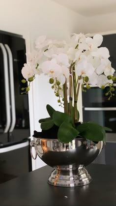 white flowers in a silver bowl on a kitchen counter